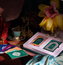 Load image into Gallery viewer, The beautiful keepsake box of The Garden Journey lying open on a beautiful table, nestled among beautiful coral, fruit, and flowers.